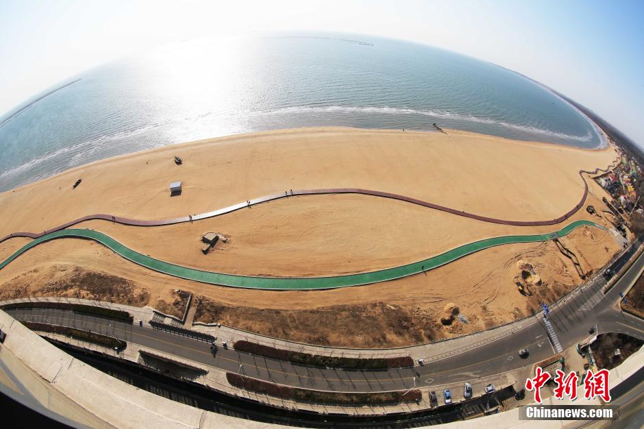 3月13日，秦皇島萬米臨海沙灘木棧道。據(jù)了解，該木棧道全長約4200米，與北戴河區(qū)原有的7500米木棧道對接后全線總長度1.17萬米，整個木棧道東起秦皇島體育基地游船碼頭，西至北戴河濕地公園，呈波浪形蜿蜒10.4公里海岸線。 中新社發(fā) 曹建雄 攝 CNSPHOTO