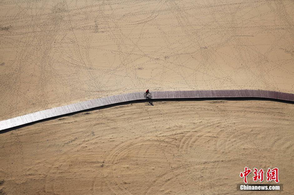3月13日，秦皇島萬米臨海沙灘木棧道。據(jù)了解，該木棧道全長約4200米，與北戴河區(qū)原有的7500米木棧道對接后全線總長度1.17萬米，整個木棧道東起秦皇島體育基地游船碼頭，西至北戴河濕地公園，呈波浪形蜿蜒10.4公里海岸線。 中新社發(fā) 曹建雄 攝 CNSPHOTO